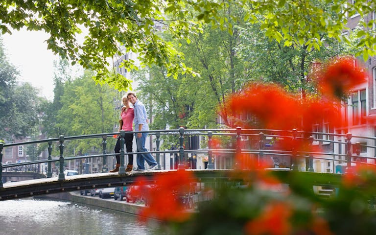 Bilde av et kjærestepar langs kanalene i Amsterdam