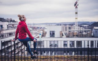 Kvinne sitter på taket av et nybygg