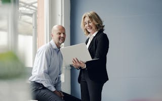 Mann og kvinne ser på laptop