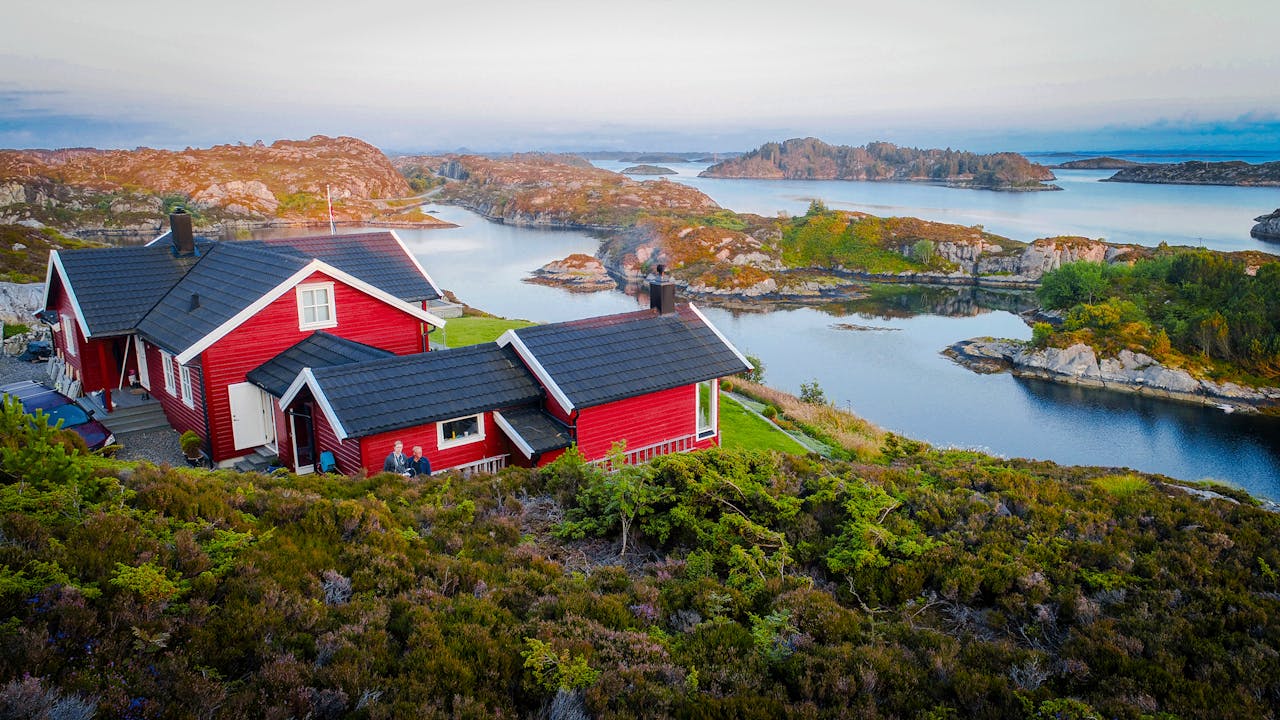 Rødt hus på svaberg ved sjøen