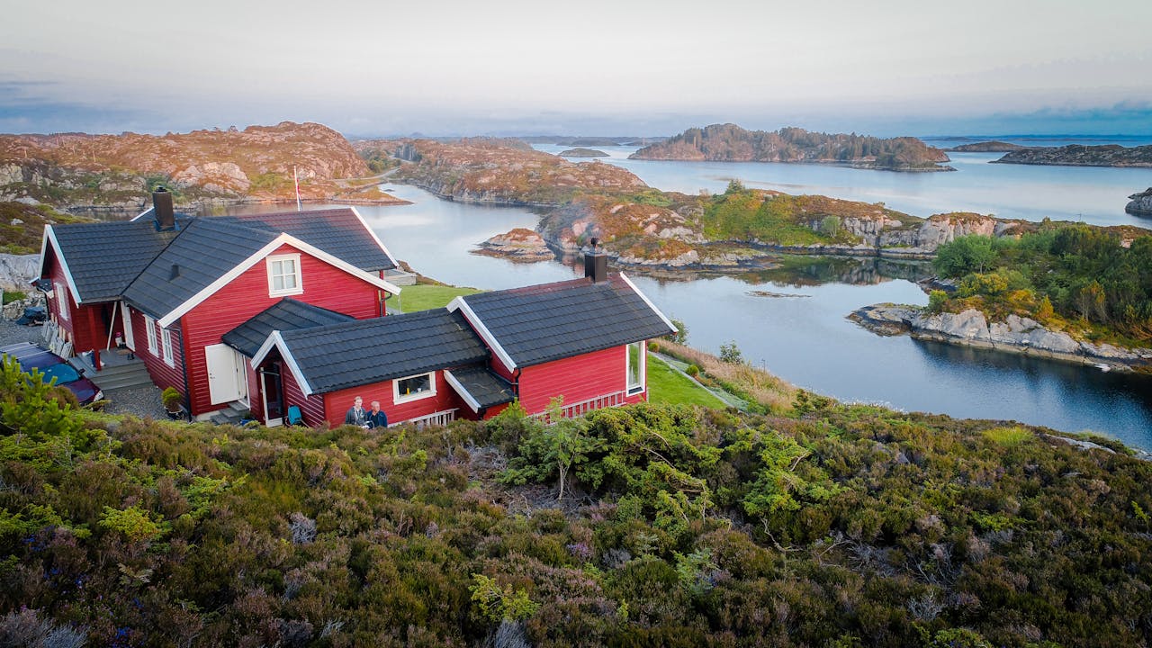 Rødt hus på svaberg ved sjøen