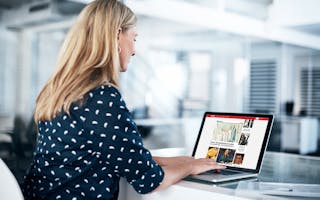 Kvinne jobber på laptop i kontorlandskap