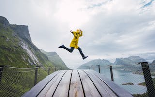 Person med gul jakke hopper ved utsiktspunkt