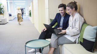 Mann og dame sitter i korridor med laptop