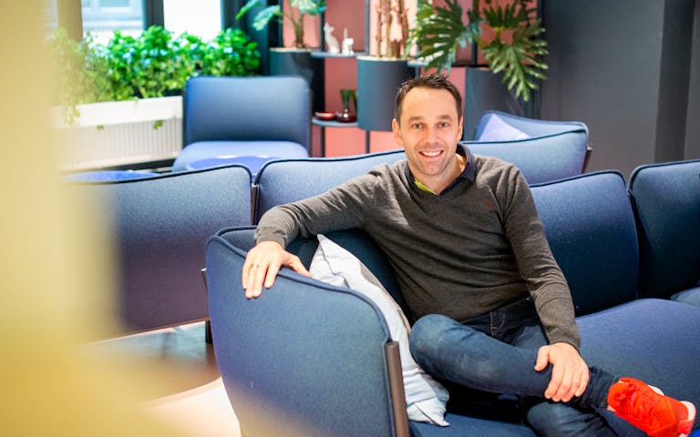 Bildet viser Lars Erik Aas, MC-ansvarlig hos FINN, som sitter i en blå sofa og smiler mot kameraet.