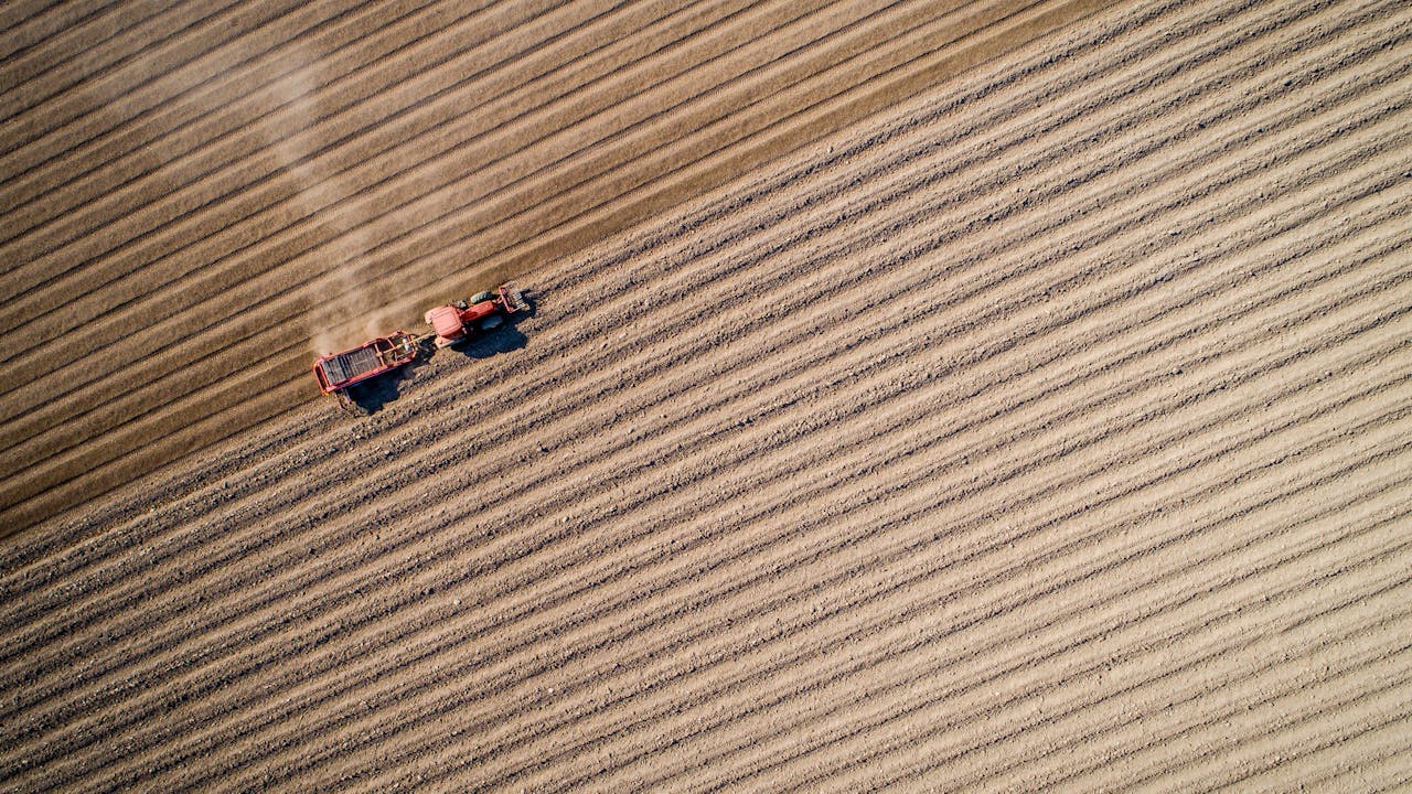 Bildet viser en traktor på et jorde i Ringsaker, tatt ovenfra