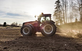 Traktor på jorde i sollys
