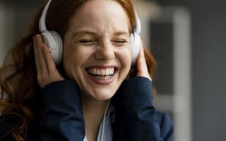 Smilende ung kvinne med hodetelefoner