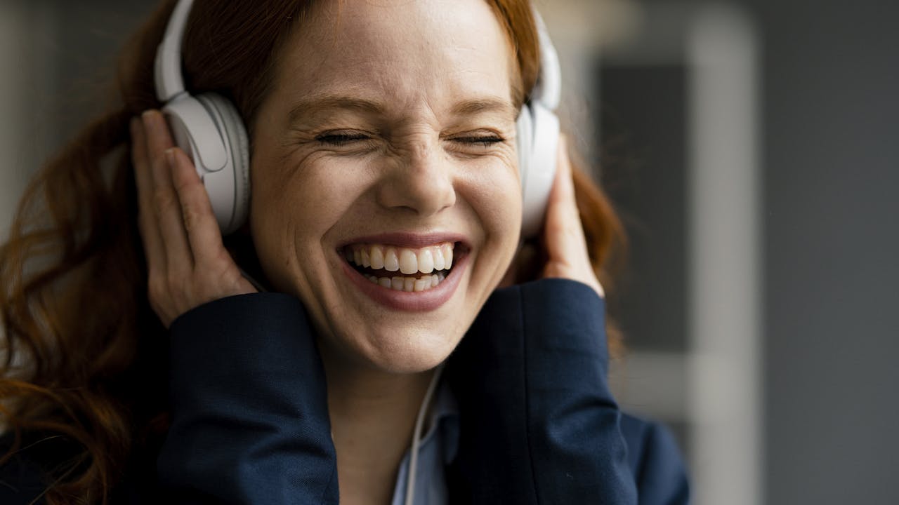 Smilende ung kvinne med hodetelefoner