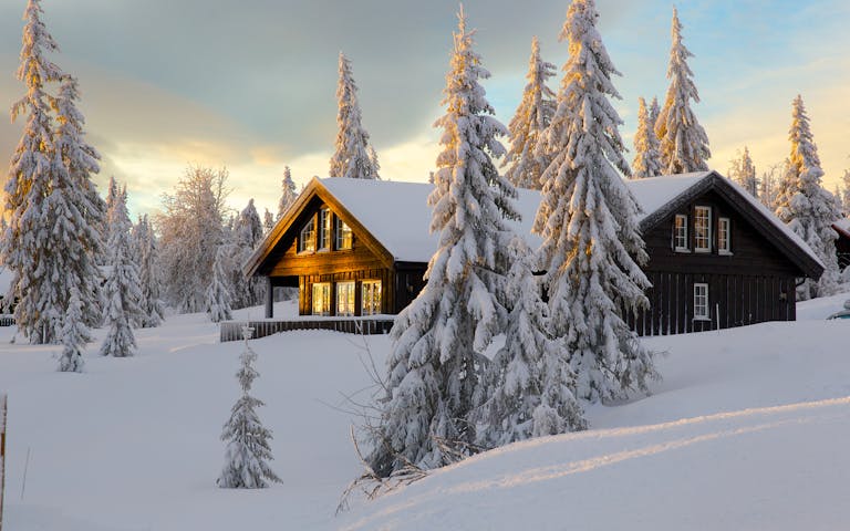 Brunbeiset hytte i norsk vinterlandskap