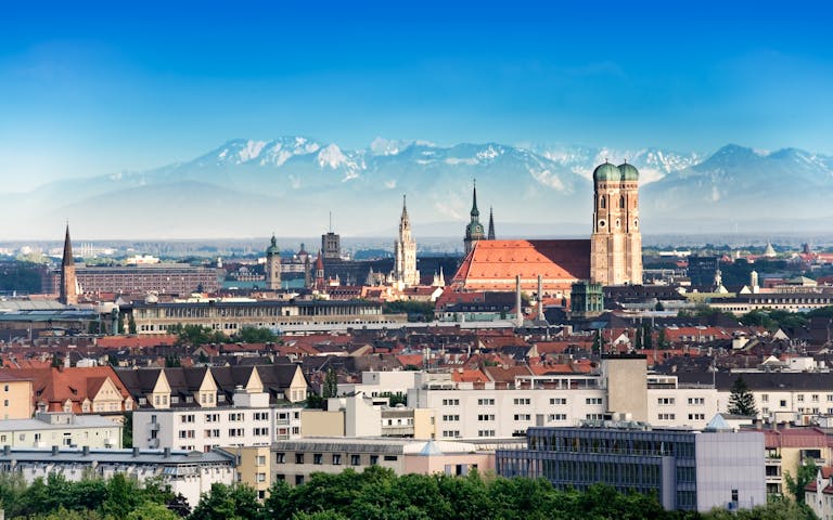 Bilde med utsikt over München og med Alpene i bakgrunnen