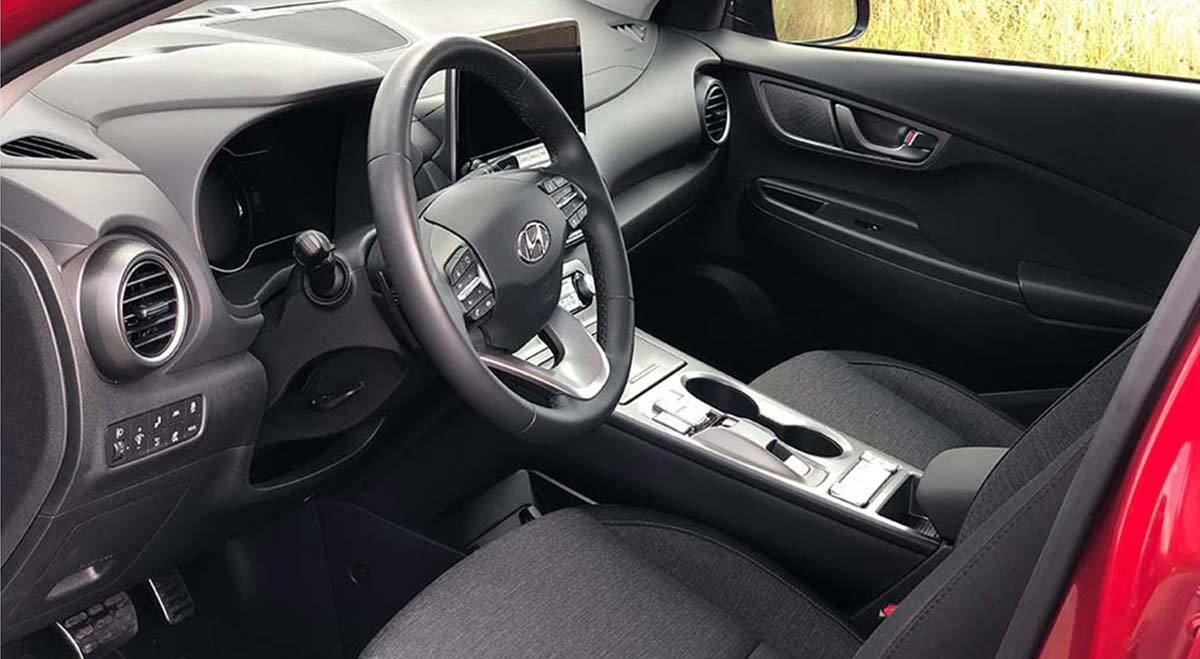 Bilde fra innsiden av bil med ratt og dashbord