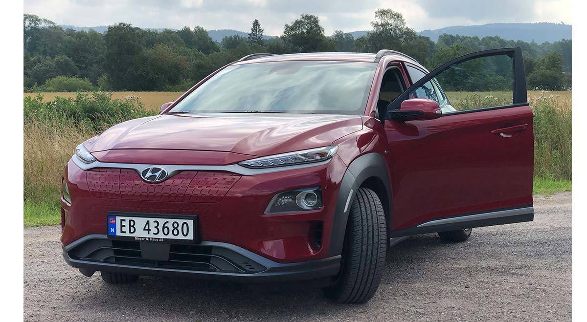 Rød bil fotografert i landlige omgivelser