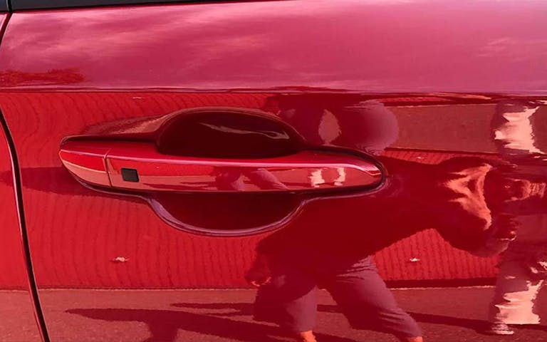 Nærbilde av bil med speilbilde av fotografen