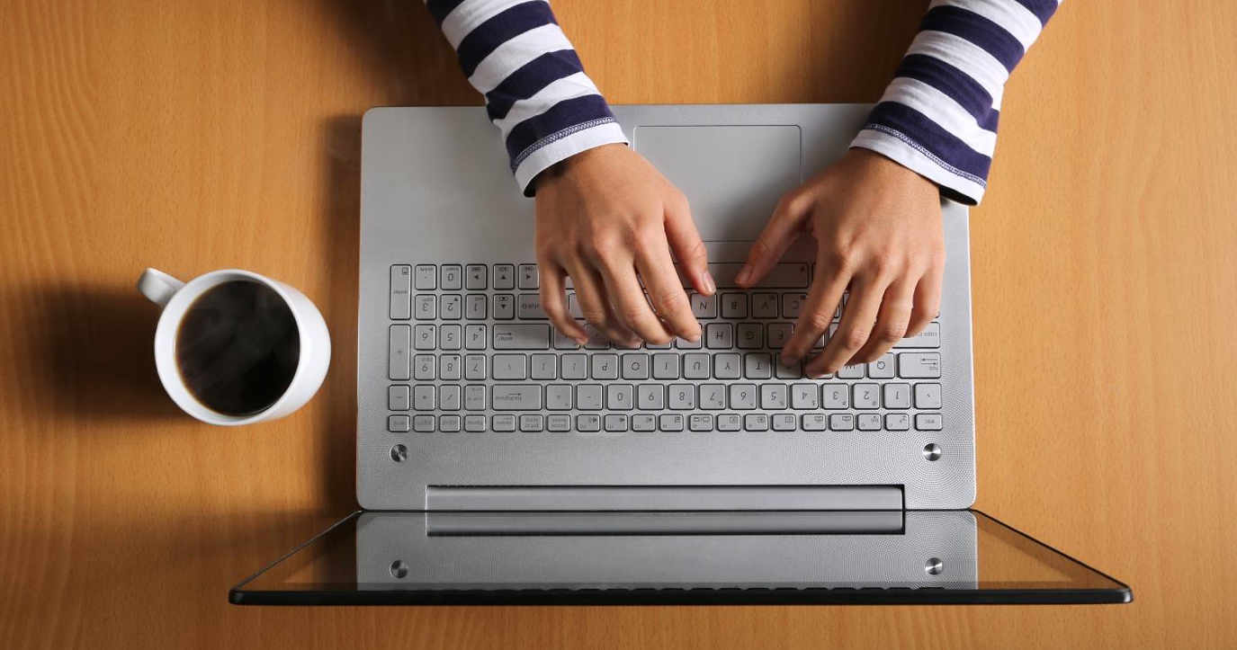 Hender jobber på laptop