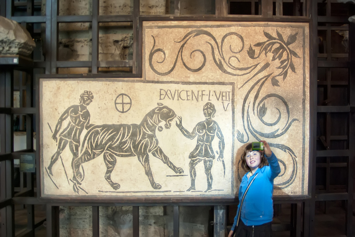 Et barn tar en selfie ved inngangen til Colosseum i Roma