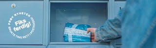 Foto: person henter en liten blå pakke med hentenummer på.