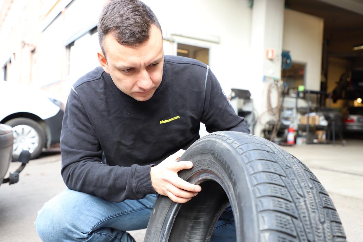 Mann sjekker mønsterdybde i bildekk